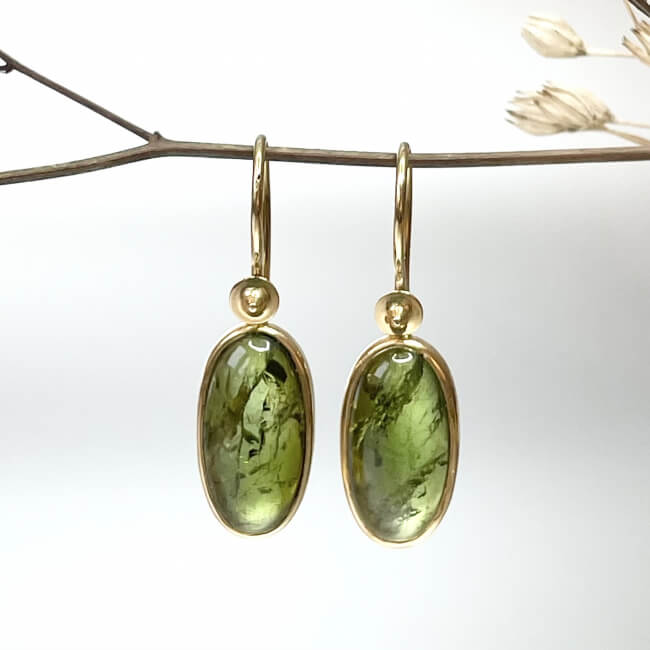 Große grüne Ohrhänger aus Gold mit sichtbarer Maserung der Steine