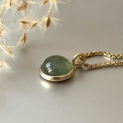 goldener anh&auml;nger mit gr&uuml;nem stein