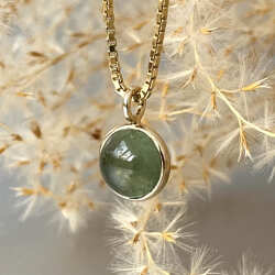 Anh&auml;nger aus gold mit gro&szlig;em gr&uuml;nem stein