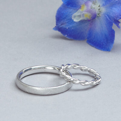 Eheringe aus Weißgold und geflochtenem Ring als Ring für die Frau. Der Ring für den Herren ist seidenmatt. 